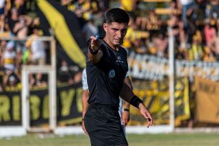 Arbitre de football consultant un écran en bord de pelouse